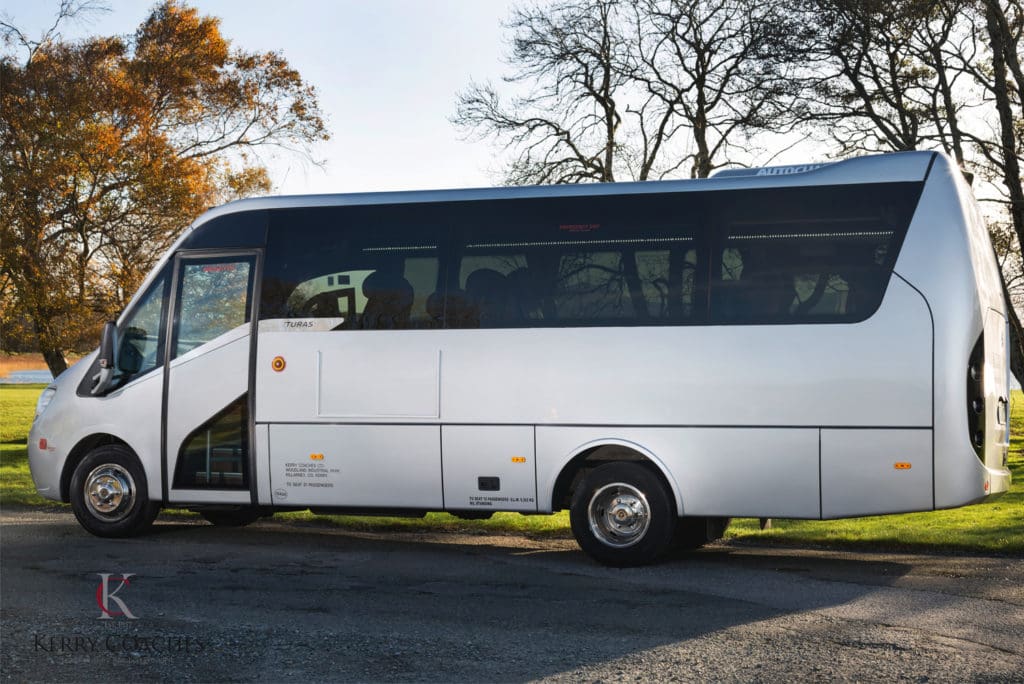 A white bus is parked on the side of the road.