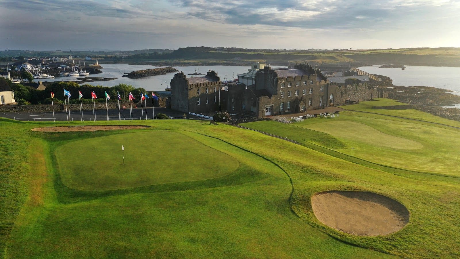 A view of a golf course with a building in the background.