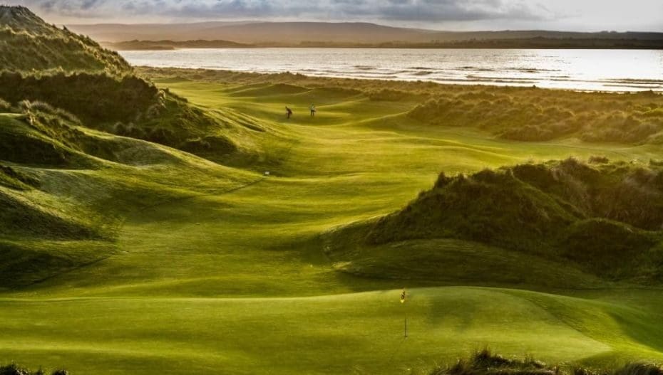 A view of a golf course with green grass.