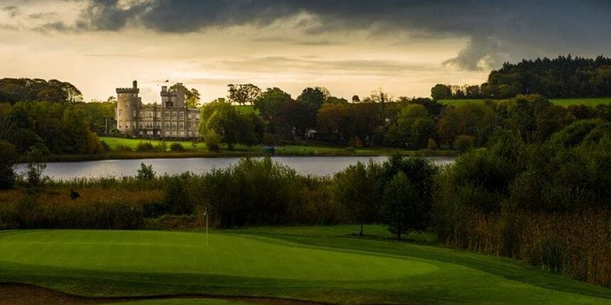 A view of a golf course with a castle in the background.