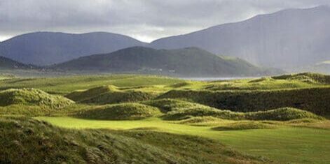 A view of the golf course with mountains in the background.